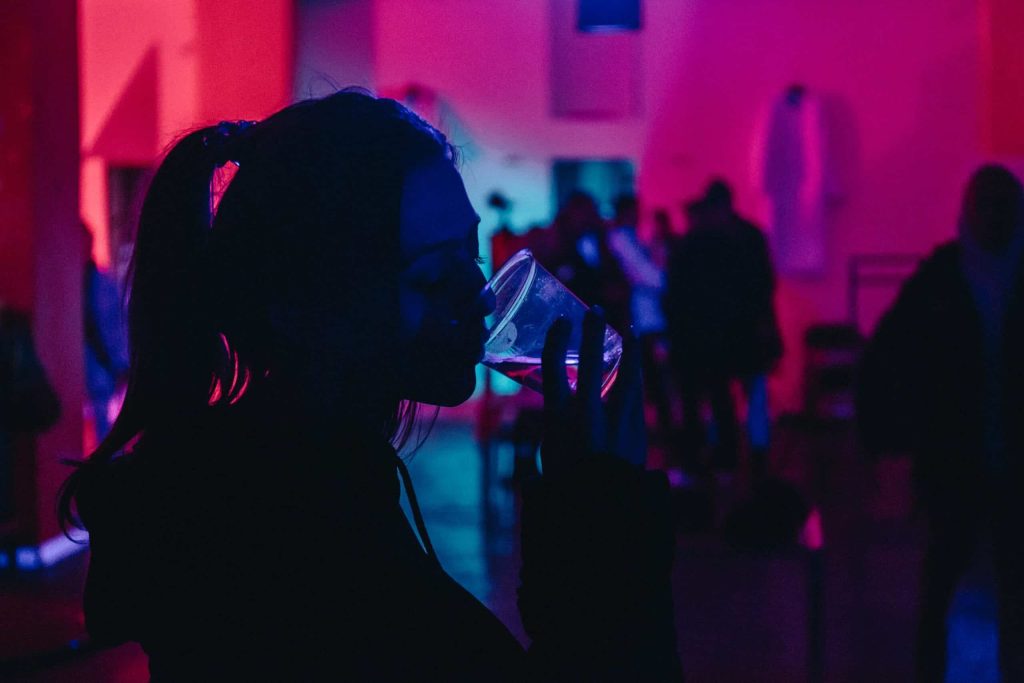 woman takes a shot of olmeca tequila without without exceeding alcohol at the party