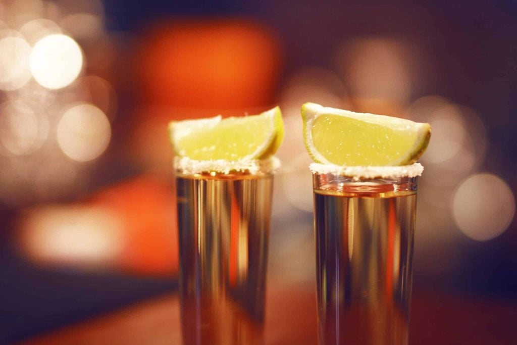 Two Olmeca tequila shots rimmed with salt and a piece of lemon