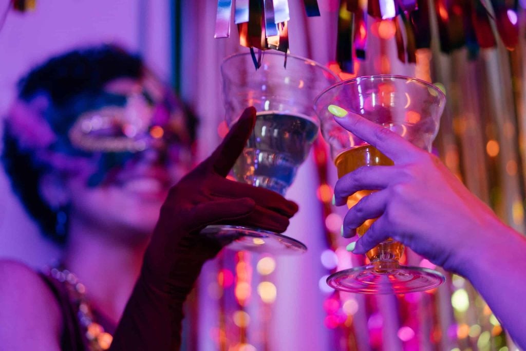 people woth mask drinking olmeca tequila shots at the party