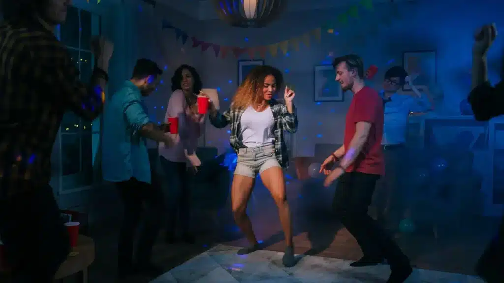 group of friends dancing in circle while holding tequila drink and enjoying the party responsibly